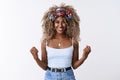 Optimistic, encouraged good-looking african american blond female with afro hairstyle, fist pump move and smiling from