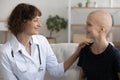 Female doctor oncologist consulting young woman receiving cancer treatment.