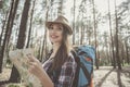 Optimistic girl hiker is traveling in pinewood