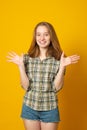 Optimistic girl raises palms from joy, happy to receive awesome present from someone, dressed in casual shirt