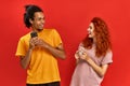 Optimistic joyful couple African American man and ginger woman in basic t-shirts looking at each other while holding