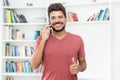 Optimistic laughing latin american hipster man talking at mobile phone Royalty Free Stock Photo