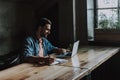 Optimistic male having labor at table indoor Royalty Free Stock Photo