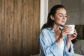Optimistic pleased girl indoors at home drinking coffee Royalty Free Stock Photo