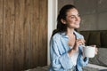 Optimistic pleased girl indoors at home drinking coffee Royalty Free Stock Photo