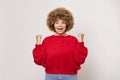 Optimistic positive busty woman with curly hair clenches fists rejoices in success personal achievements wears red Royalty Free Stock Photo