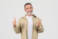 Elderly person giving thumbs up gesture on white background