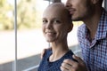 Optimistic young female receiving cancer treatment hugged by beloved male Royalty Free Stock Photo