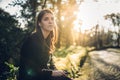 Optimistic young woman listening to music podcast stream over headphones,enjoying in nature at sunset.Musical therapy.Day in Royalty Free Stock Photo