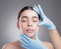 Opting for plastic surgery. Studio shot of an attractive young woman having some plastic surgery done against a grey