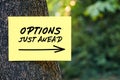 Options just ahead motivational message written on paper on a tree in nature. Inspirational quote to create future in business or Royalty Free Stock Photo