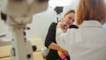 Optometrist checks little girl`s eyesight - mother and child in ophthalmologist room Royalty Free Stock Photo