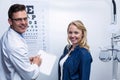 Optometrist discussing eye test report with female patient