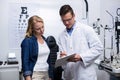 Optometrist discussing eye test report with female patient Royalty Free Stock Photo