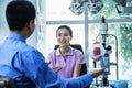 Optometrist discussing with young woman in his clinic