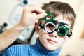 Optometrist doctor examines eyesight of child boy with phoropter