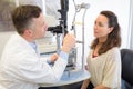 Optometrist in exam room with woman in chair