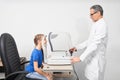 Optometrist examining eyesight of patient with slit lamp. Royalty Free Stock Photo