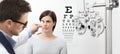 Optometrist examining eyesight, woman patient pointing at the ch Royalty Free Stock Photo