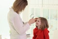 Optometrist examining little girl eye in doctor premise Royalty Free Stock Photo