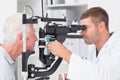 Optometrist examining senior patients eyes through slit lamp