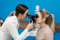 Optometrist looks into eye using an ophthalmoscope. Ophthalmoscopy. Ophthalmologist examines the eyes of woman with