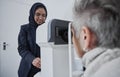 Optometrist, muslim woman and testing eyesight health in optometry lab with optical machine indoors. Senior patient in