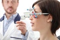 Optometrist with trial frame examining eyesight woman patient i Royalty Free Stock Photo