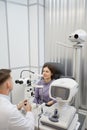 Optometrist Using Equipment while Examining Patient