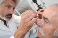 Optometrist using mydriatics eye drops to numb eyes