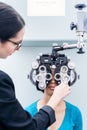 Optician and woman at eye examination with phoropter Royalty Free Stock Photo