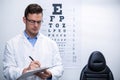 Optometrist writing on clipboard