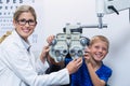 Optometrist and young patient smiling while under going eye test Royalty Free Stock Photo