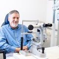 Senior patient sitting the exmanination chair , before having his eyes examined by an eye doctor