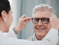 Optometry, ophthalmology and optometrist fitting glasses on senior man patient or happy client during appointment