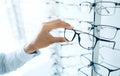 Optometry store, eyeglasses and hands of person shopping for lens frame decision, retail product or prescription eyewear Royalty Free Stock Photo