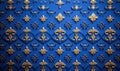 An opulent background featuring a repeated pattern of golden fleur-de-lis on a royal blue surface. Royalty Free Stock Photo