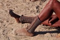 Opuwo, Namibia - Jul 07, 2019: Himba women with the typical foot jewelry in a himba tribe village