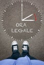 Ora Legale, Italian Daylight Saving Time on asphalt with two shoes, high angle from above