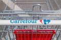 Logo and sign of Carrefour on shopping cart. Carrefour is French multinational retail and wholesaling corporation