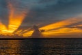 Orage color sun rays through clouds during sunset in Indian ocean Royalty Free Stock Photo
