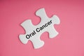 ORAL CANCER text with white jigsaw puzzle on pink background Royalty Free Stock Photo