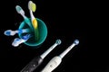 Oral Care Ideas. Pair of Professional Electric Toothbrushes In Front of Four Manual Toothbrushes Placed on One Cup