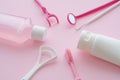 Oral care kit dental cleaning tools tongue cleaner, mirror, toothbrush, toothpaste, dental floss, mouthwash on pink background