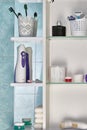 Oral care products and other hygiene items on shelf in bathroom cabinet Royalty Free Stock Photo