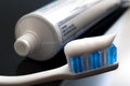 Oral health and dental hygiene concept with a toothbrush covered in toothpaste with the toothpaste tube in defocused in the
