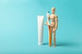 Oral hygiene and dental care. Wooden man holds toothbrush and toothpaste