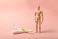 Oral hygiene and dental care. Wooden man holds toothbrush and toothpaste