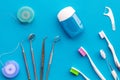 Daily oral hygiene for family. Toothbrush, dental floss and dentist instruments on blue background top view