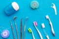 Daily oral hygiene for family. Toothbrush, dental floss and dentist instruments on blue background top view